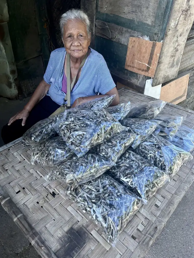 A vendor with her day's catch of dried fish